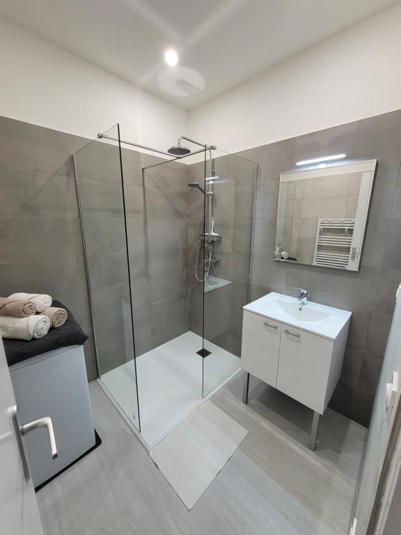 Un baño con ducha de cristal y lavabo. en APPARTEMENTS DANS VILLA EN REZ DE JARDIN, en Hyères