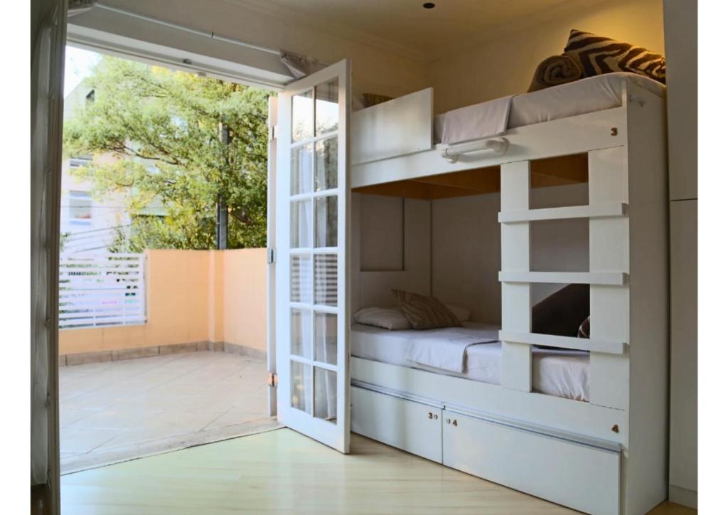 a bedroom with a bunk bed with a door open at Villa Hostel in São Paulo