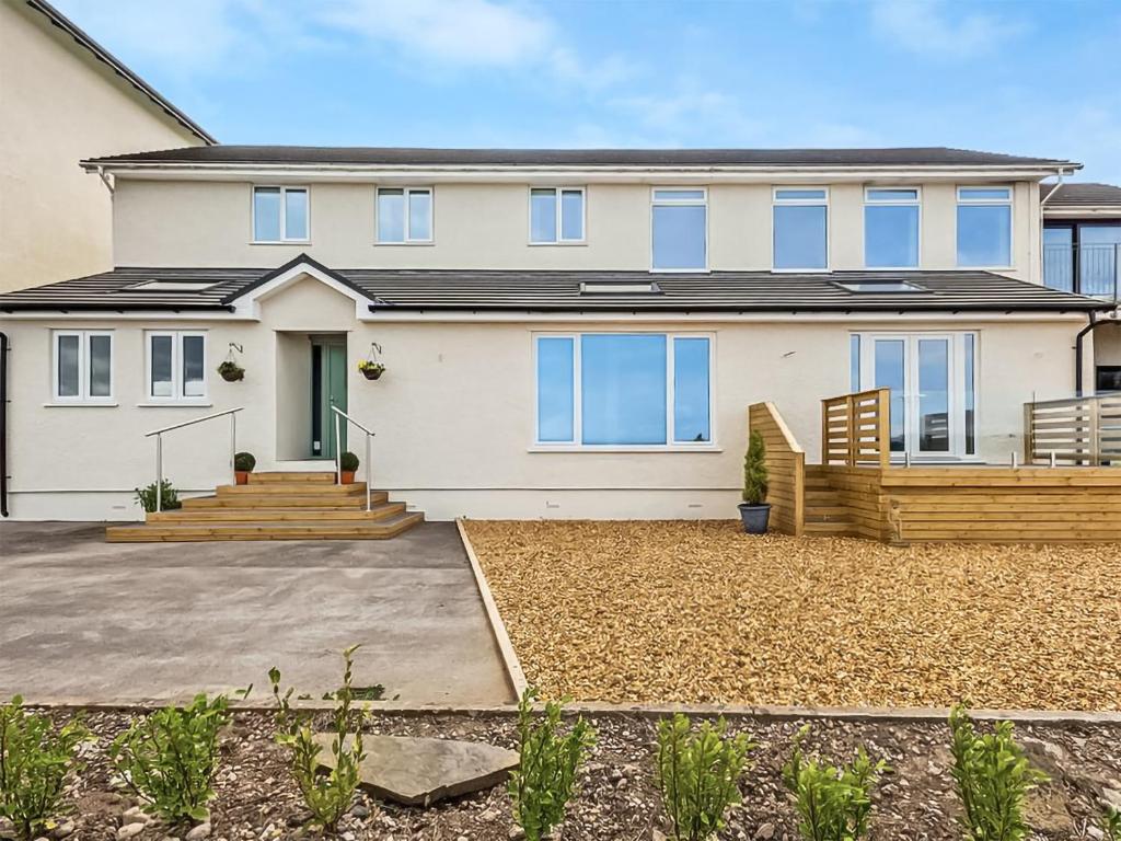 a large white house with a large yard at Dunlin Haven in Sandside