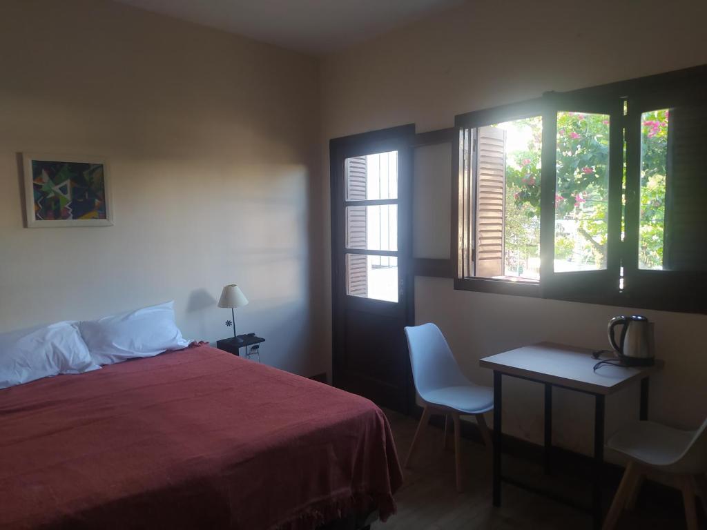 1 dormitorio con 1 cama, 1 mesa y 2 ventanas en Garden dream en San Salvador de Jujuy