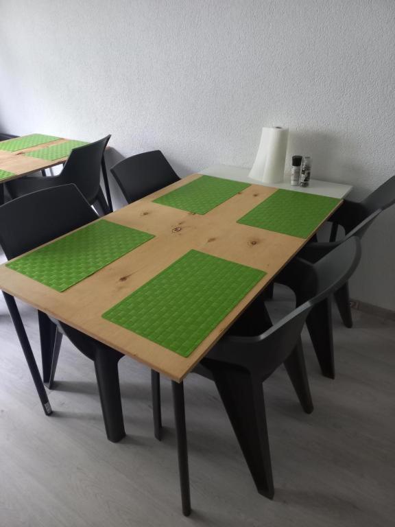 a wooden table with black chairs around it at rooms & kitchen - Günstige Langzeitmiete in Pohlheim