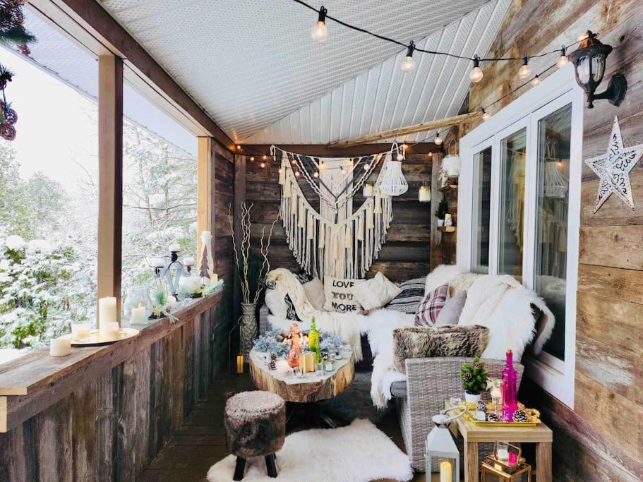 a screened in porch with a couch and a table at Cozy Chalet by lake & Nature in Saint-Raymond