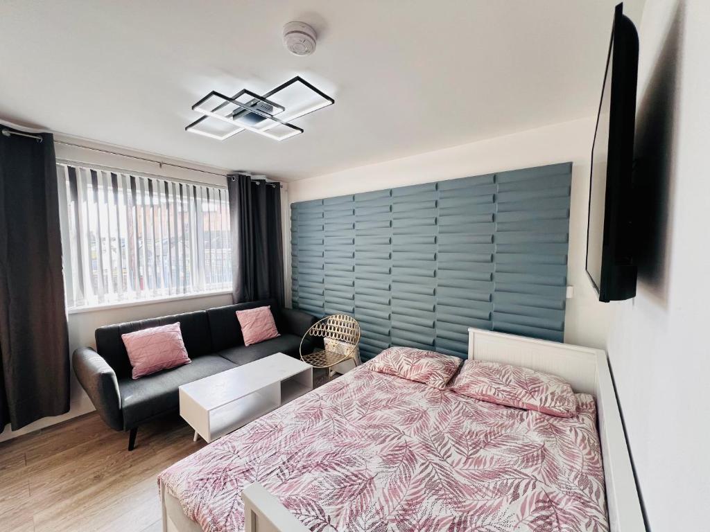 een slaapkamer met een bed en een bank bij City Studio Apartment Swansea - Includes Free Parking in Swansea