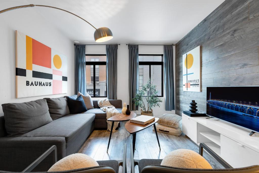 uma sala de estar com um sofá e uma televisão em Liv MTL Urban em Montreal