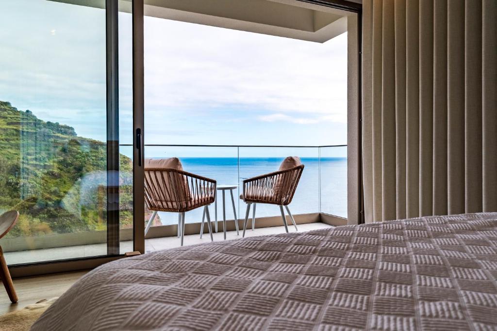 a bedroom with a view of the ocean at One Sweet World in Calheta