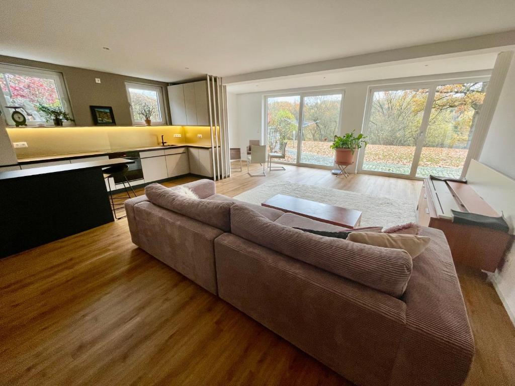 a large living room with a couch and a piano at SONNENWEG Designwohnung mit Gartenblick in Plauen