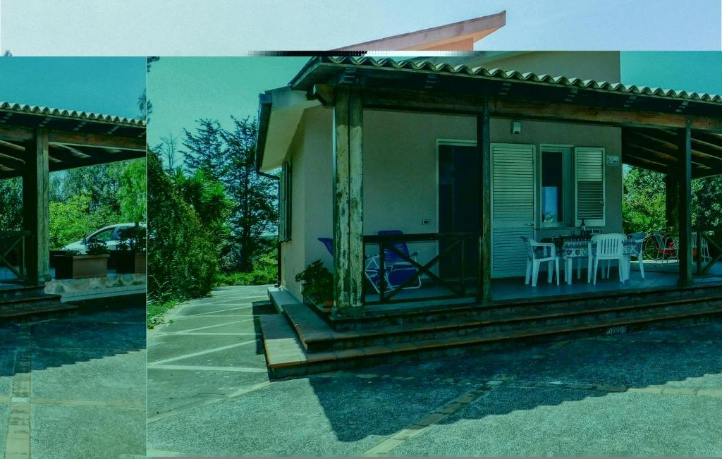 a house with a porch with a table and chairs at La Pineta in Lido Signorino