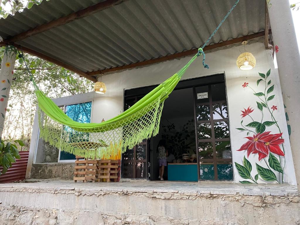 een groene hangmat die buiten een huis hangt bij Alojamiento Rural Las Melinas 