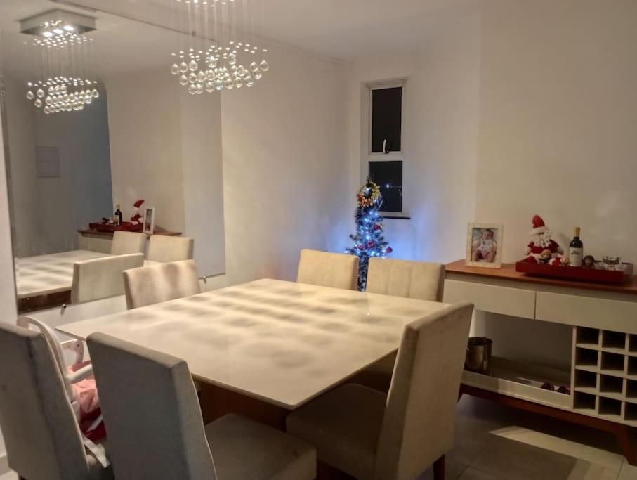a dining room with a table and a christmas tree at Apart° Grande Lar in Guarapari
