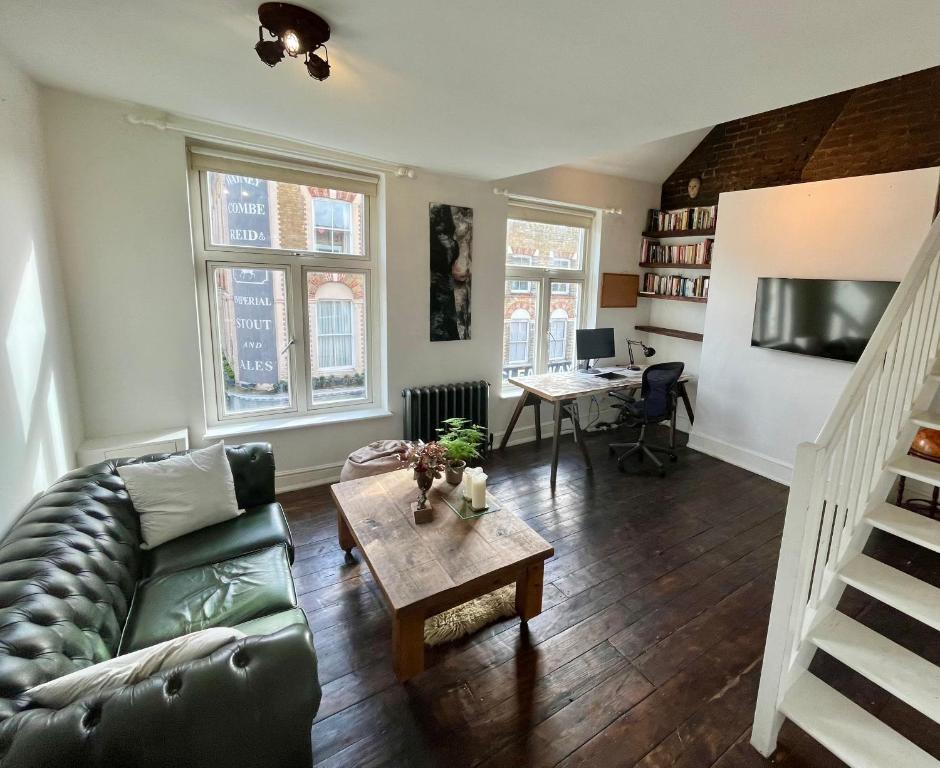 a living room with a couch and a table at Lofty split-level period flat in Highbury in London