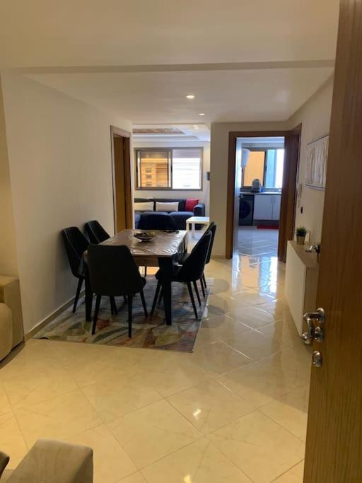 a dining room and living room with a table and chairs at Appart familial chic & confort in Kenitra