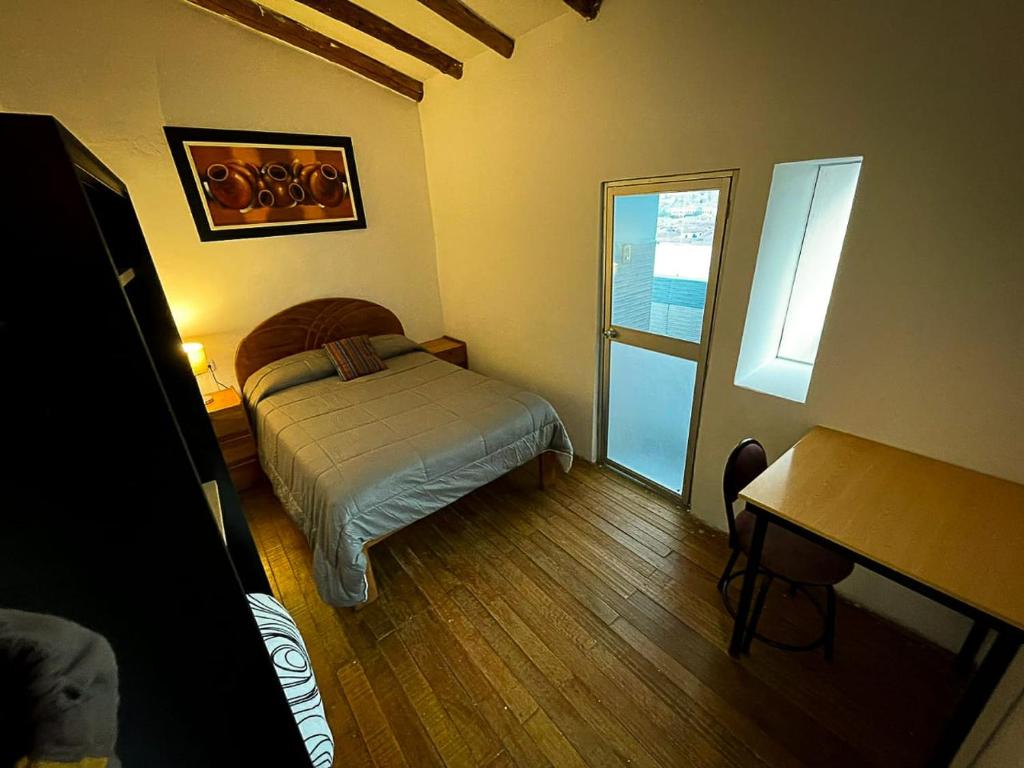 una piccola camera da letto con un letto e una finestra di Casa Cusco guest house a Cuzco