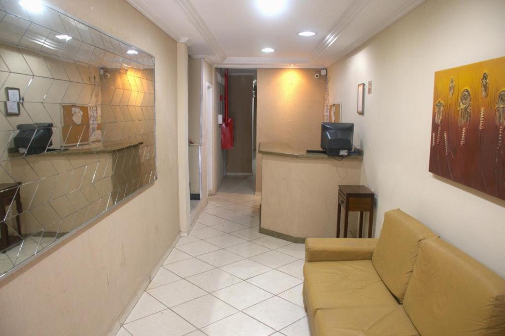 een woonkamer met een bank en een bar bij Pé da Serra Hotel in Resende