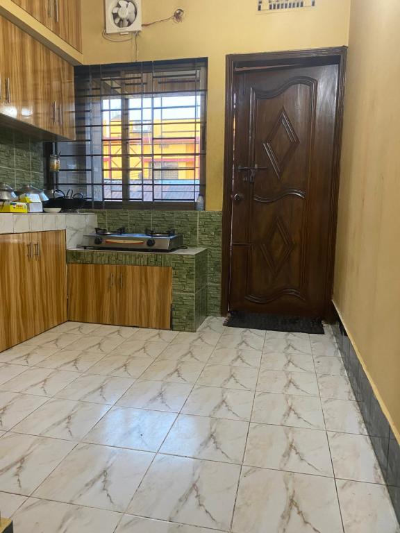 a kitchen with a wooden door and a tile floor at Holiday home in Sylhet (Kasobir) in Kilsby