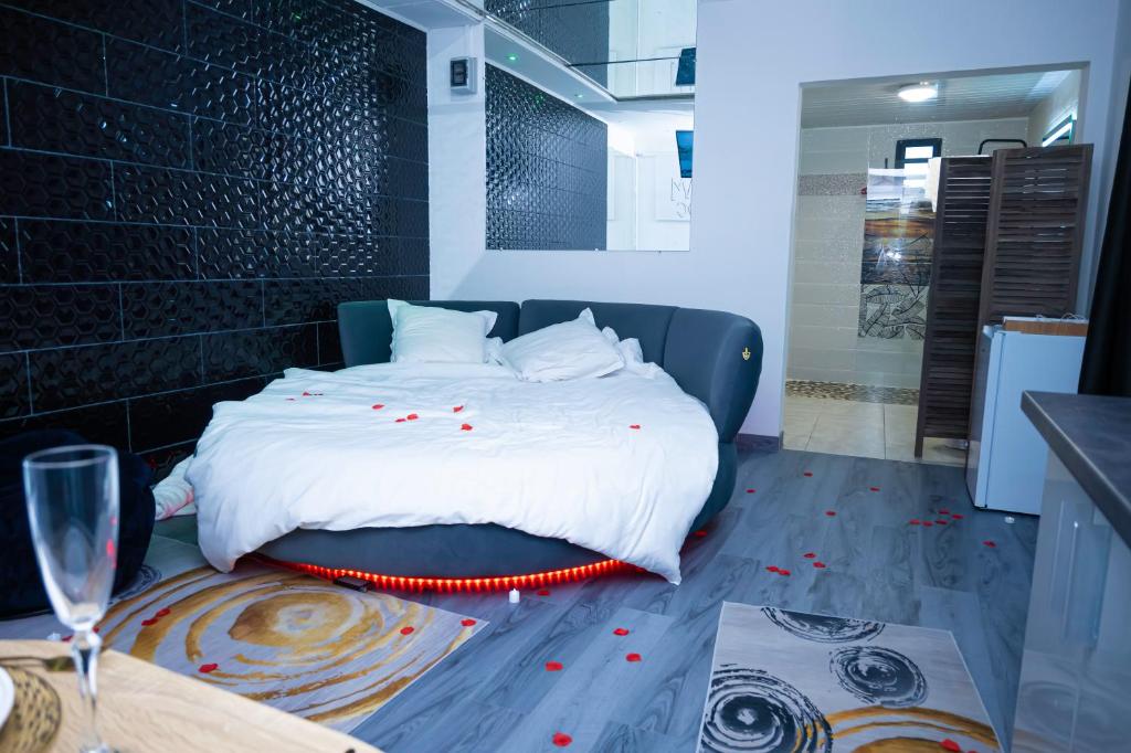 a bedroom with a bed with red petals on the floor at JDREAMLOC in Kourou