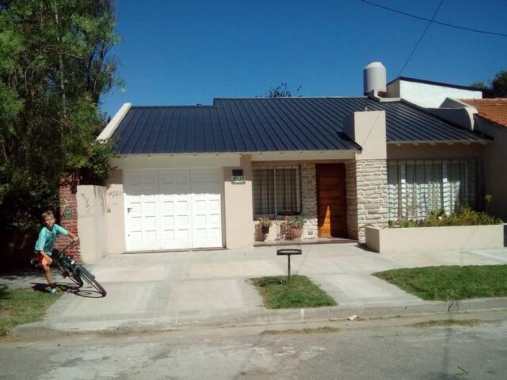 a boy riding a bike in front of a house at MIRAMAR CHALET in Miramar