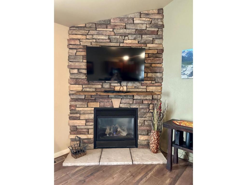 a stone fireplace with a tv on top of it at Sweet Pea in Red Lodge
