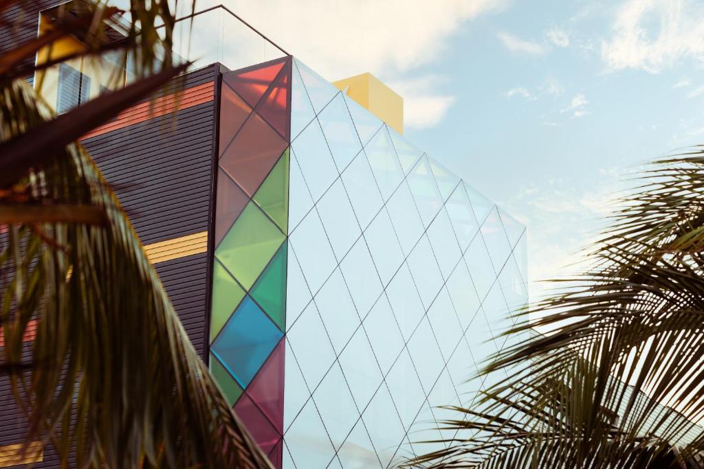 a building with a colorful facade with a palm tree at Prixma Hotel in San Andrés