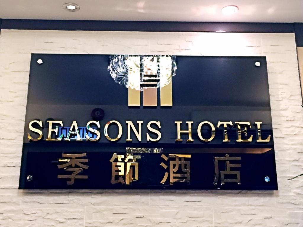 een bord voor een seizoenhotel aan een muur bij Seasons Hotel in Hong Kong