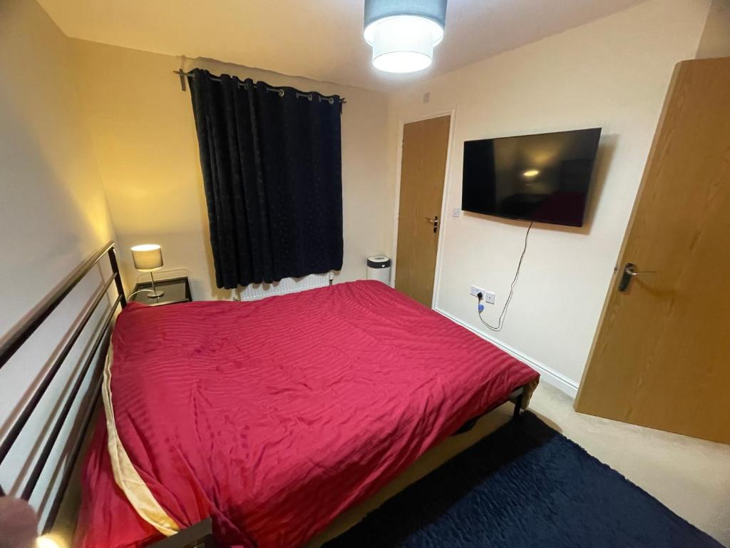 伯明罕的住宿－Luxury ensuite room near city centre，一间卧室配有一张带红色毯子的床