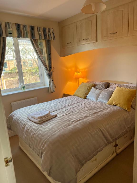 ein Schlafzimmer mit einem großen Bett und einem Fenster in der Unterkunft Cosy 3 bedroom house in Stoke on Trent