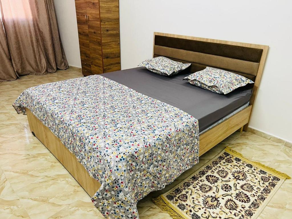 uma cama com duas almofadas num quarto em À 2 pas de la medina em Kairouan