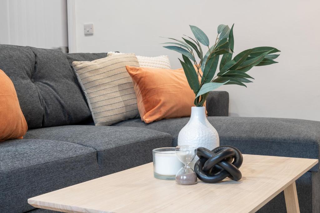 a coffee table with a vase and a plant on it at Aviary Nest by Nordstay in Amley