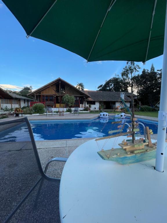 a table with an umbrella next to a swimming pool at Quinta Suria in Quito