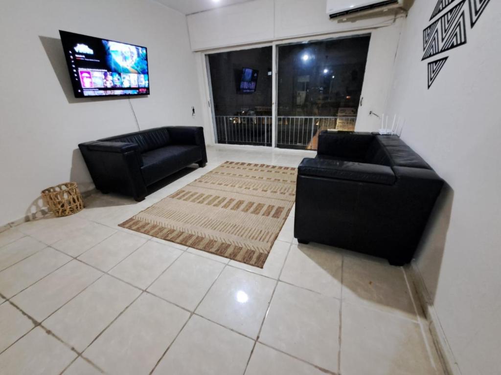 ein Wohnzimmer mit einem Sofa und einem TV in der Unterkunft Casona con Barbacoa en Av princ in Montevideo
