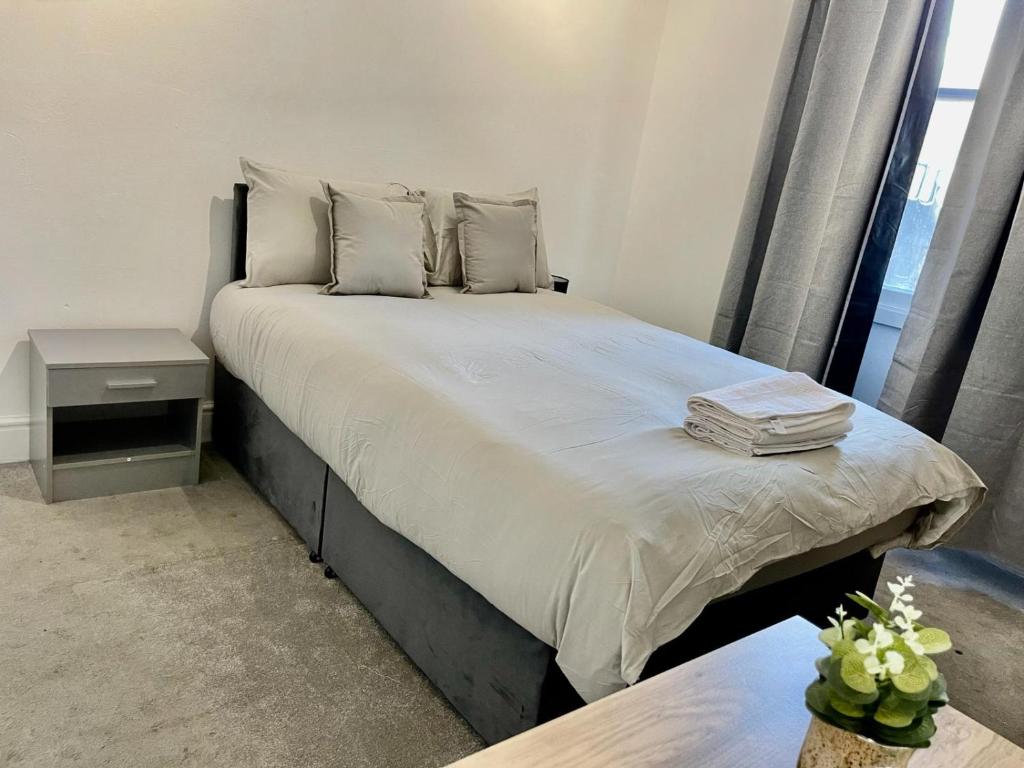 a bed with white sheets and pillows in a bedroom at Comfortable flat in Stokes Croft in Bristol