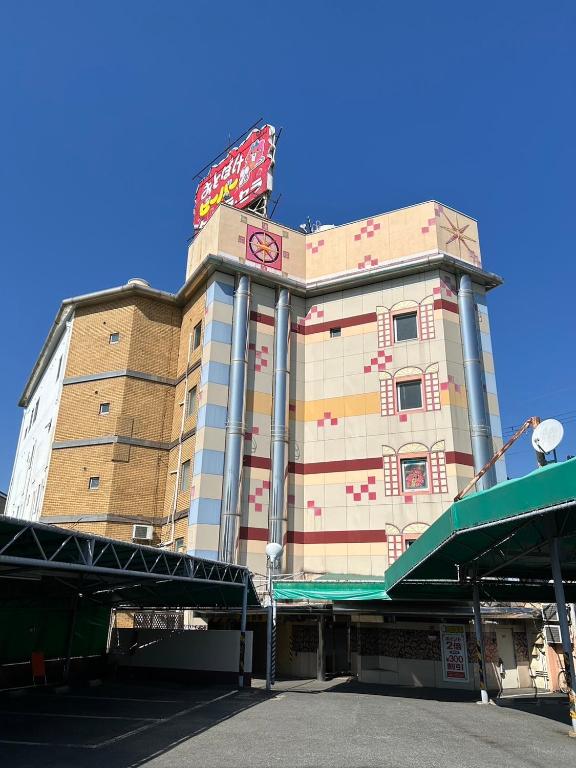 un edificio con un cartel encima en おとぼけビーバーケセラセラ寝屋川, en Neyagawa