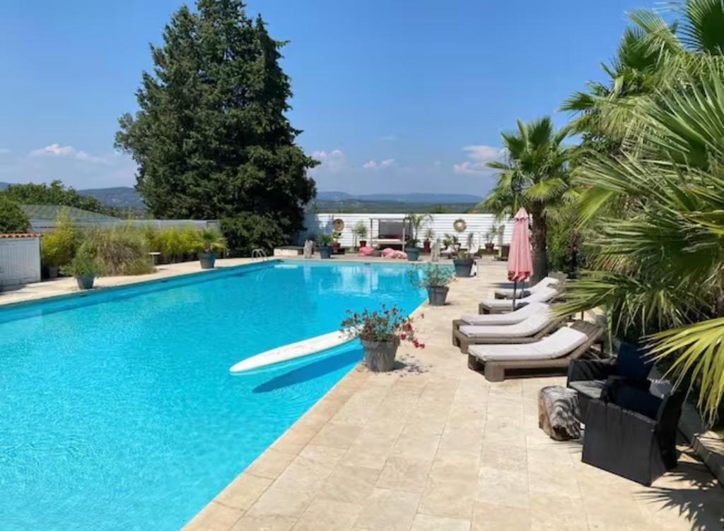 una piscina con tumbonas y sombrillas en DOMAINE DE LA SOURCO - Villa, Maisons & Chalet, Magnifique Havre De Paix En Provence en Trans-en-Provence
