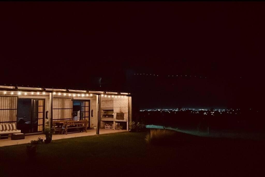 a house with lights on the side of it at night at Chacra El Timbó in Tacuarembó