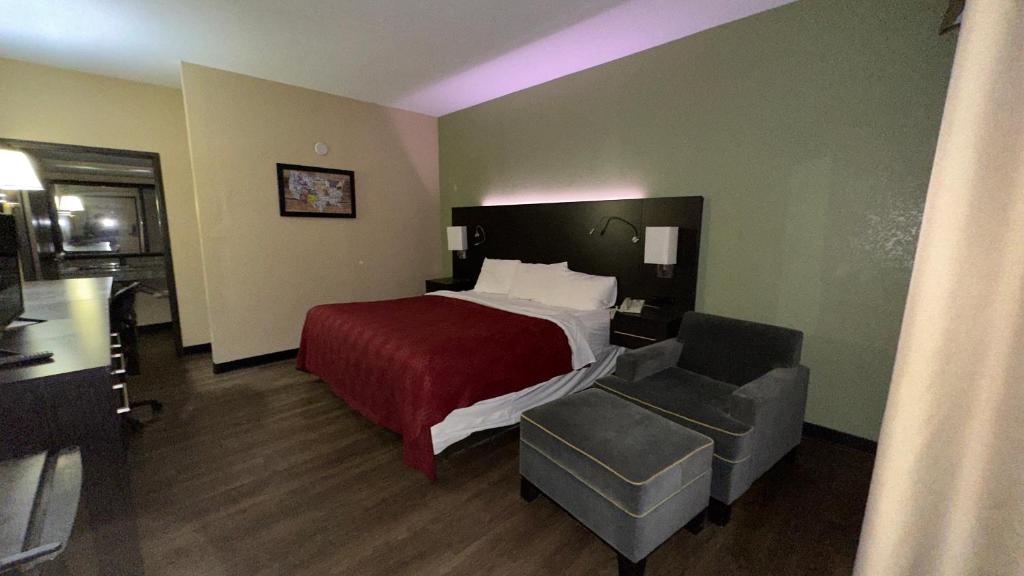 une chambre d'hôtel avec un lit et une chaise dans l'établissement Econo Lodge Belton - Kansas City South, à Belton