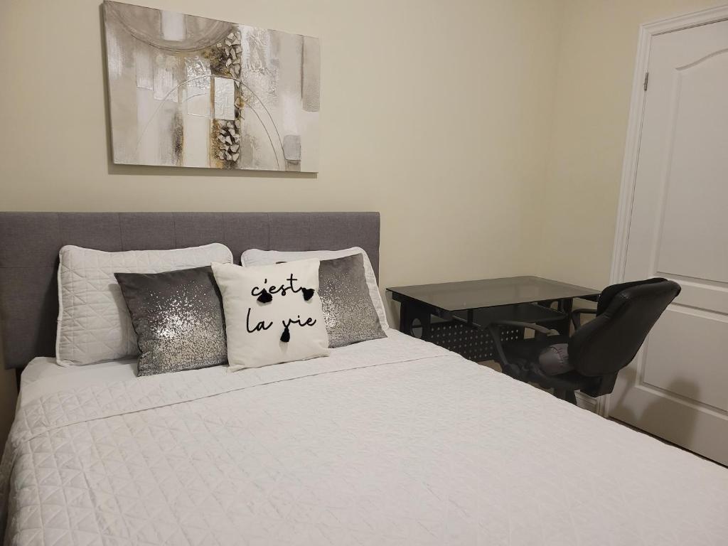 a bedroom with a white bed with pillows and a desk at Jack & Jill Private Suite @RoseGlen Place in Stamford