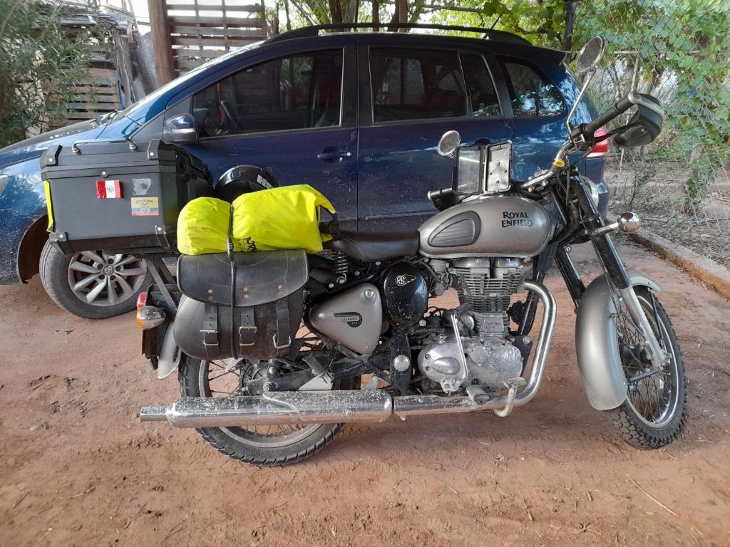 a motorcycle parked in front of a blue car at Hospedaje Familiar Raza Mistica in Villa Unión