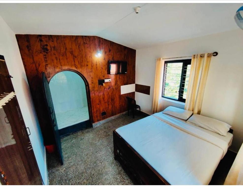 um quarto com uma cama e uma grande janela em Streaming Valley Independent Coffee Estate Stay em Madikeri