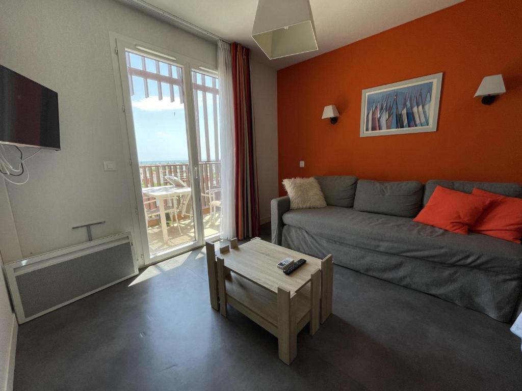 un salon avec un canapé et une grande fenêtre dans l'établissement Appartement 2P à Sète avec Piscine, Clim, Parking et Proche Plages - FR-1-338-556, à Sète