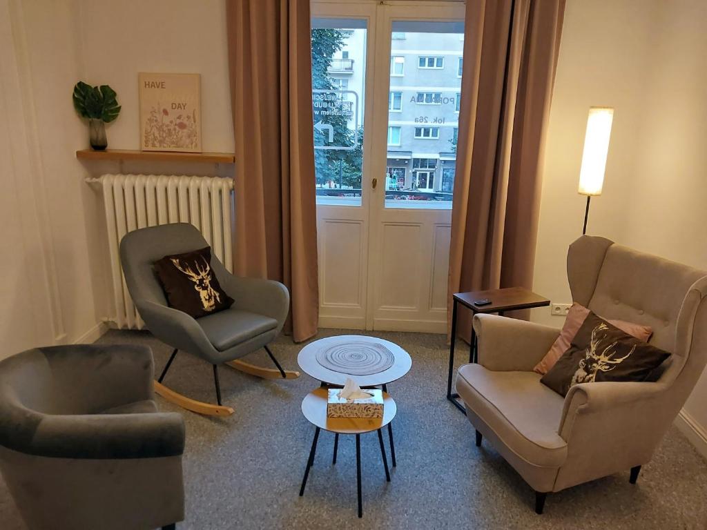 a living room with two chairs and a table at MOKOTOWSKA STREET in Warsaw