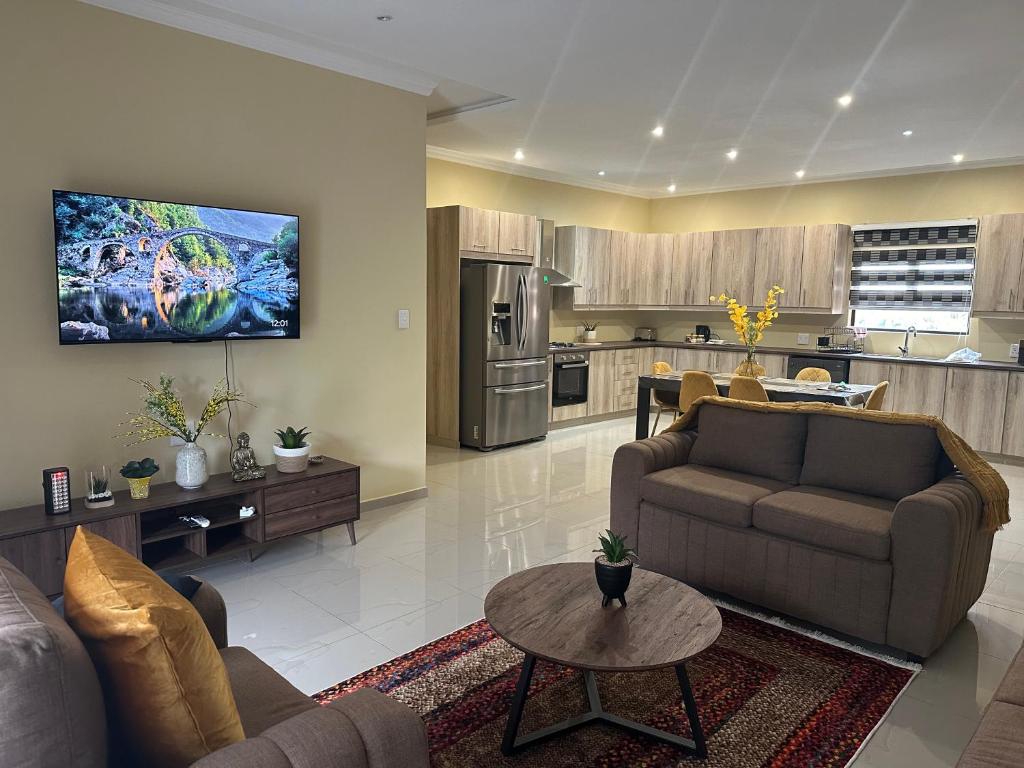 a living room with two couches and a kitchen at Six64 on KINGSWAY B5 in Amanzimtoti