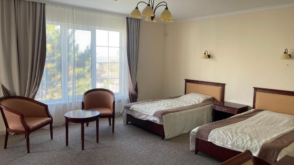 Cette chambre comprend 2 lits et une fenêtre. dans l'établissement Luxury-Family-Cottage, à Bosteri