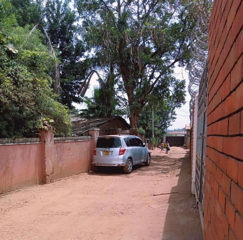 a car parked in a parking lot next to a wall at Cozy Pad in Kampala