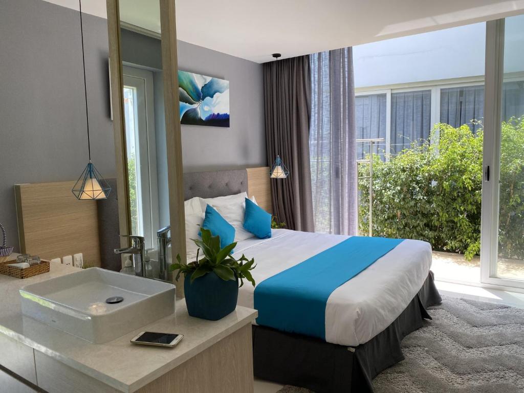 una camera d'albergo con un letto e un lavandino di Khách Sạn - Resort Oceanami - Long Hải a Long Hai