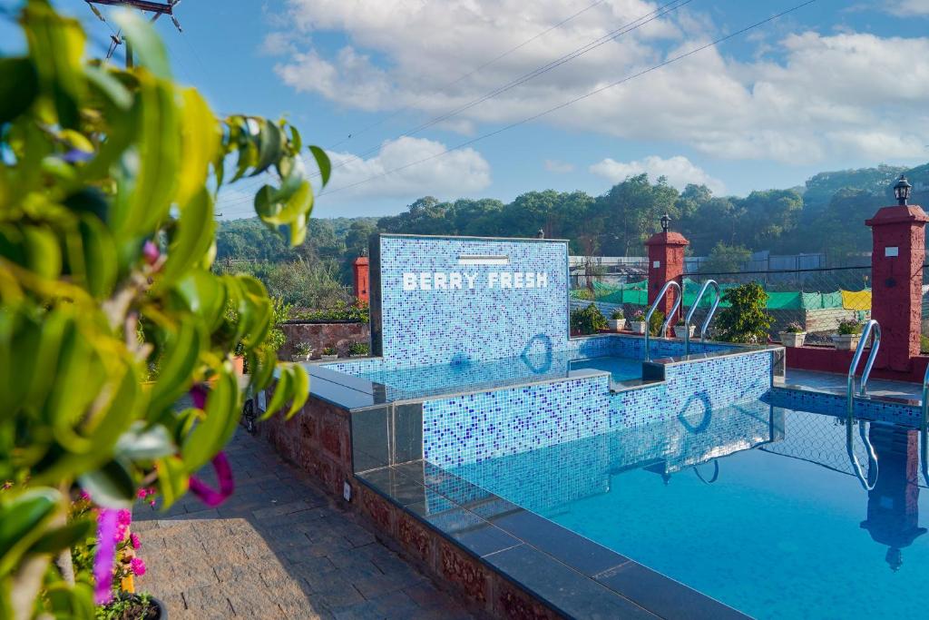 una piscina del resort con un cartello che legge Energy Hotel di Berry Fresh Stays Mahabaleshwar With Pool a Mahabaleshwar