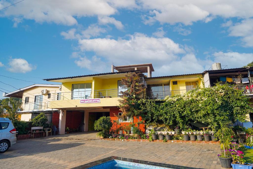 una casa gialla con una piscina di fronte di Berry Fresh Stays Mahabaleshwar With Pool a Mahabaleshwar