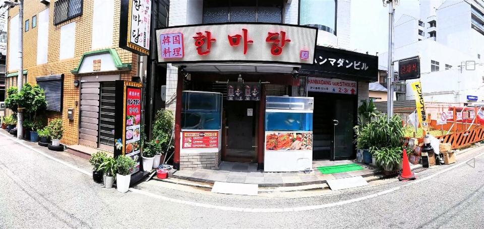 a building with a sign on the side of a street at Hanmadang in Osaka