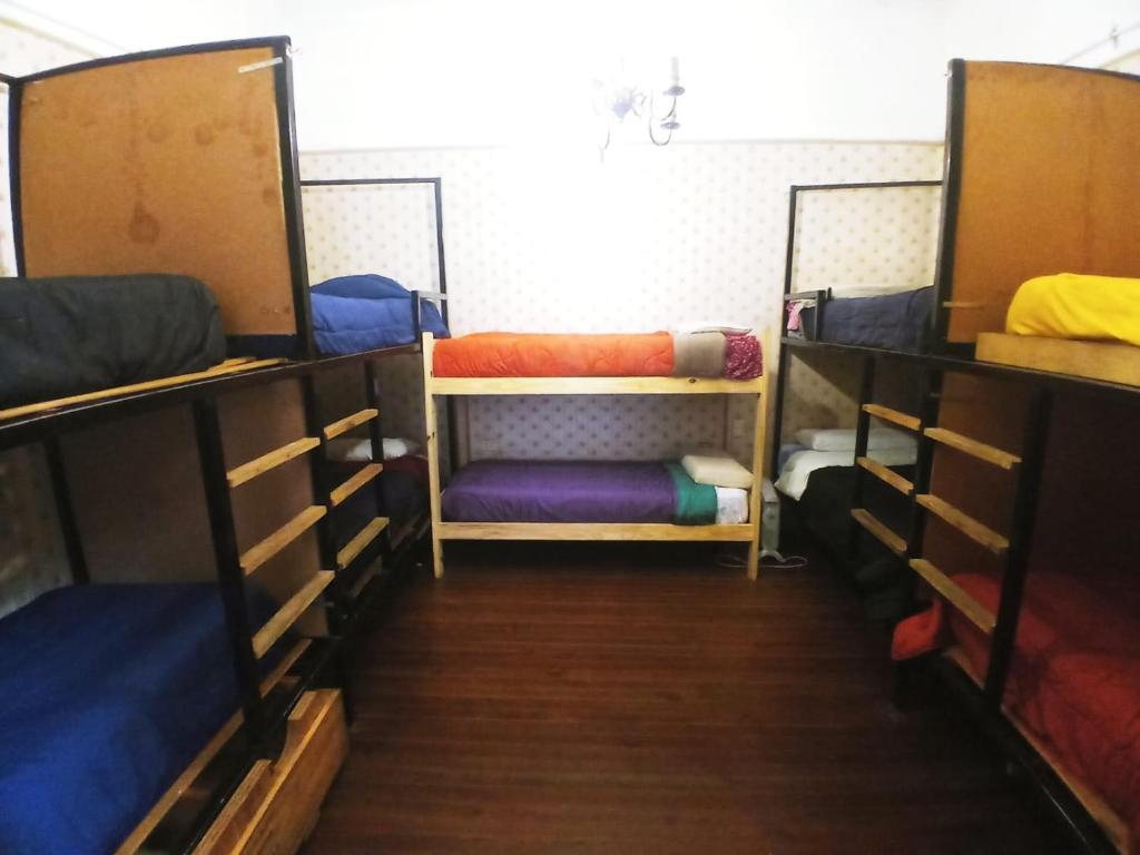 a room with three bunk beds in a room at En La Plata Hostel El Pampa in La Plata