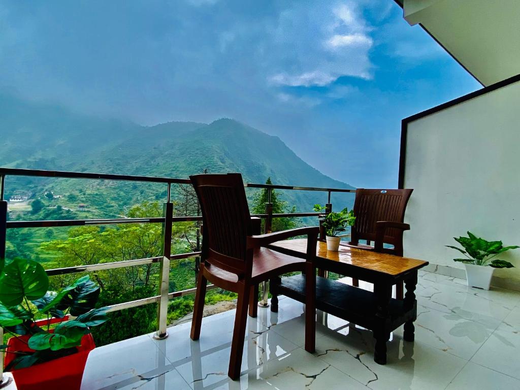 uma varanda com uma mesa e cadeiras e uma vista em The Four Season Resort - Top Rated & Most Awarded Property in Mussoorie em Mussoorie