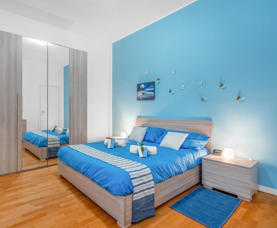una camera da letto con pareti blu e un grande letto di [Free park- San Siro - Mediolanum Forum 15 min] a Milano