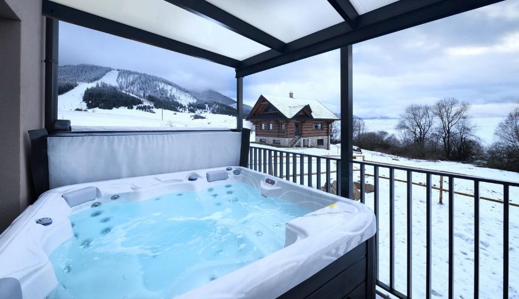 a jacuzzi tub on a balcony with a view at Sky-House Jasná Apartments in Pavčina Lehota